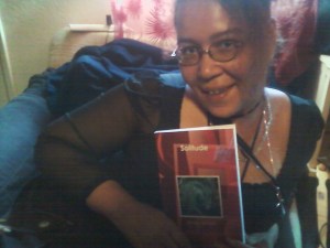 Sumiko Saulson holding a copy of her book Solitude