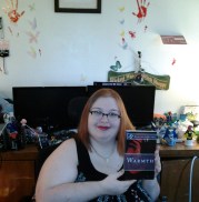 Kateryna Fury - holding a copy of Sumiko Saulson's "Warmth."